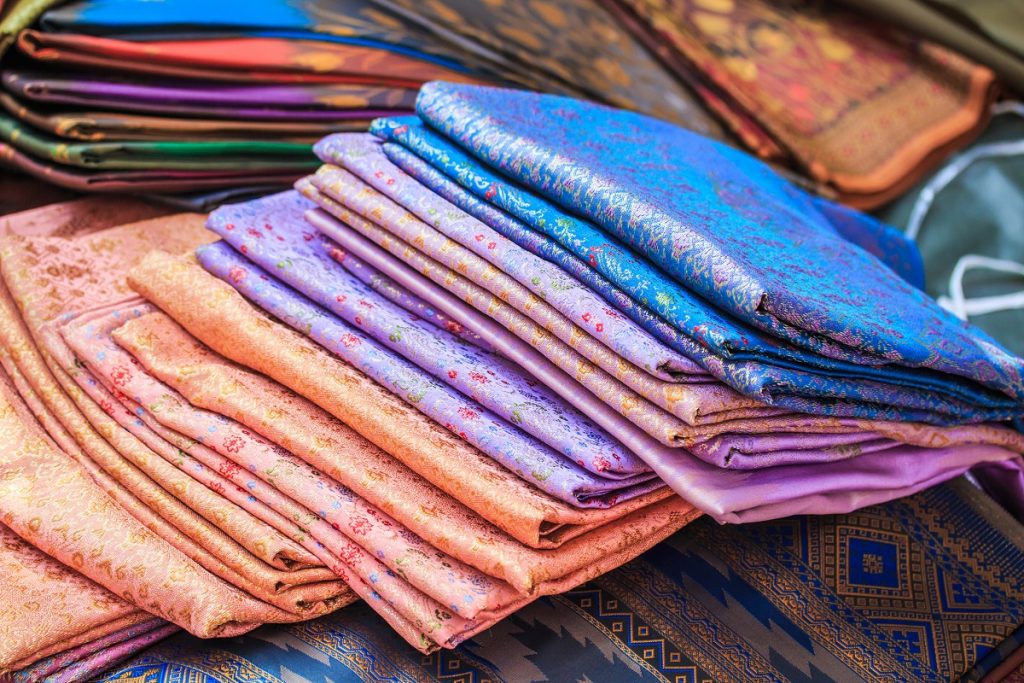 Different kinds of fabric piled up on a table