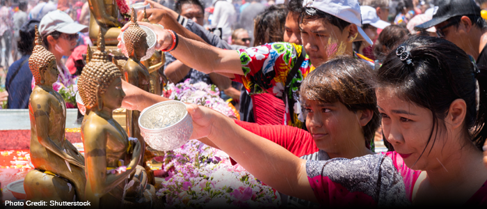 Local Thais pouring water over Buddha statues to pay homage during Songkran