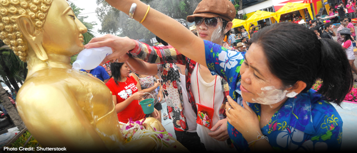 Local Thais pouring water over Buddha statues during Songkran festival